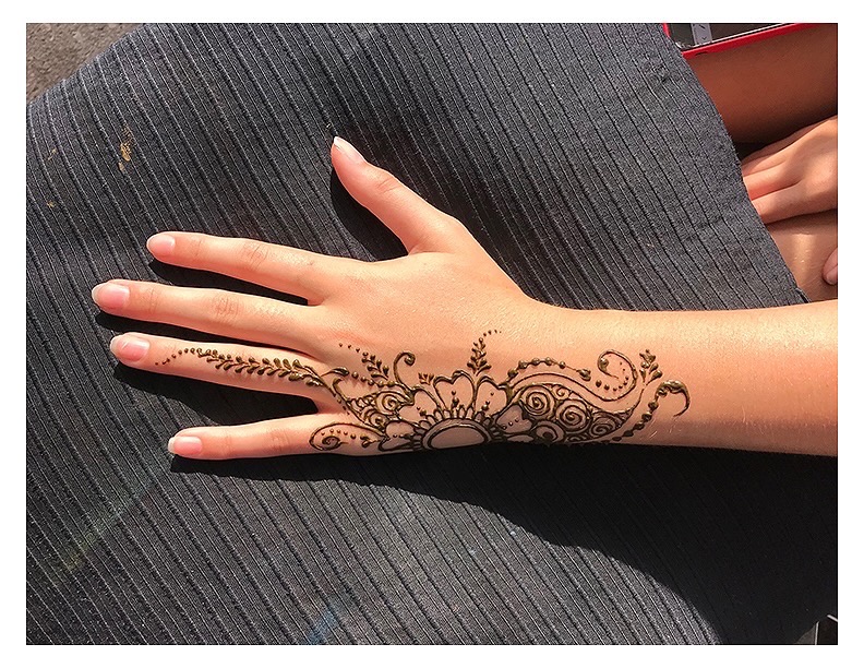Henna artist creating designs at a party